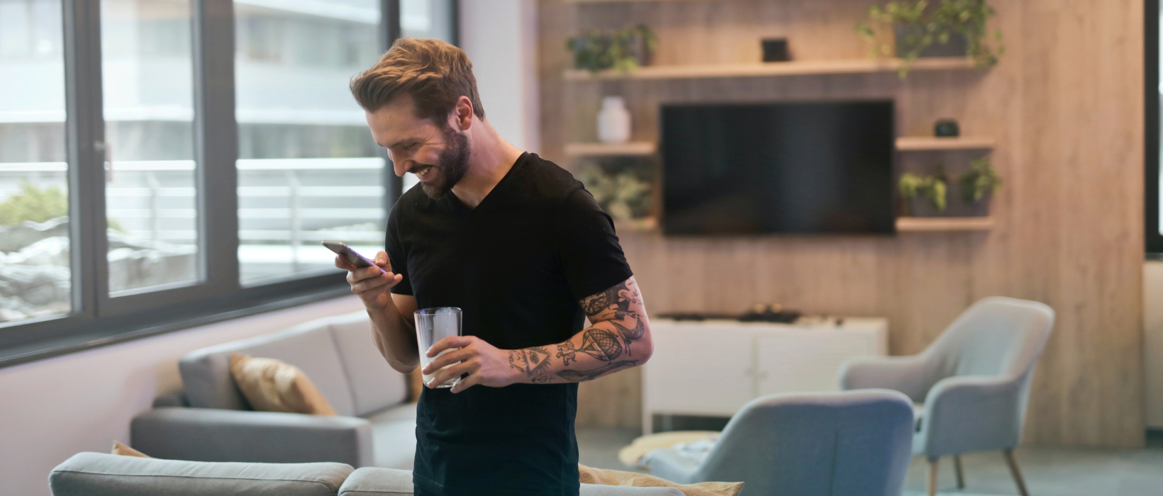 imagen de masculino con su smartphone feliz de usar el home banking